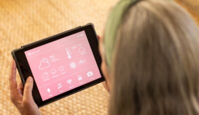 Using tablet, woman managing smart home settings and checking weather forecast